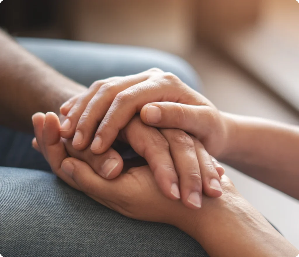 Hands gently holding each other, showing support.