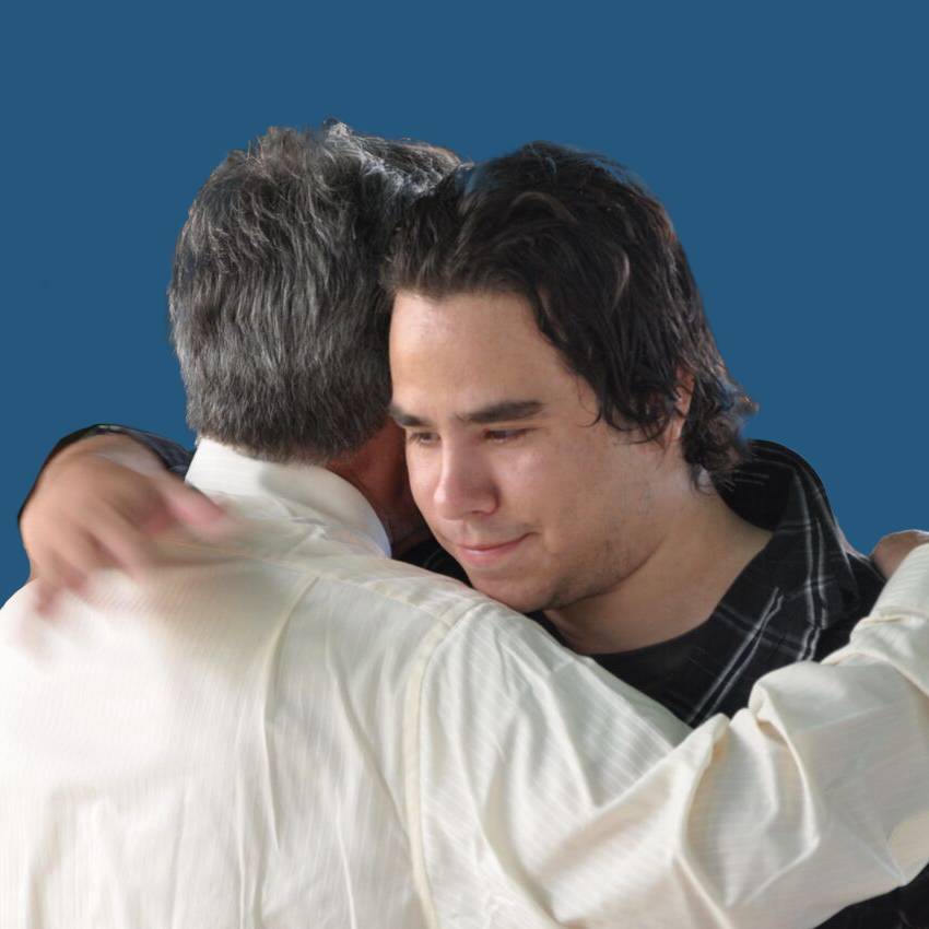 Young man hugging older man warmly