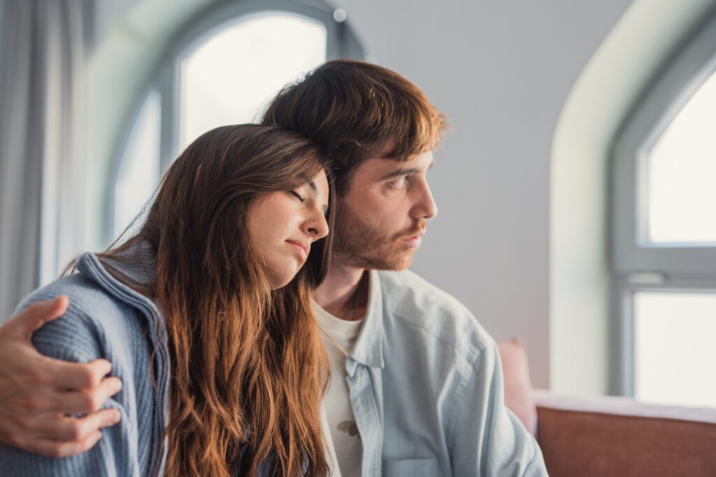 Two people sitting together in a calm setting, offering support during a difficult moment.