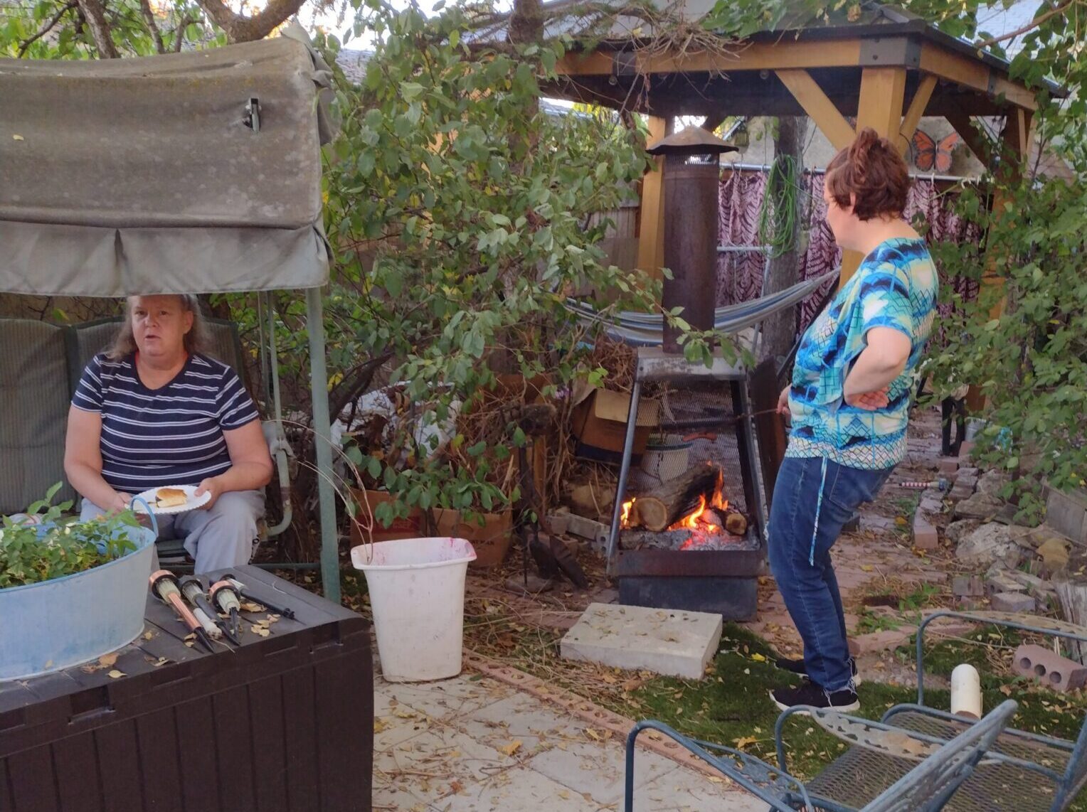 Two women near backyard fire pit and swing
