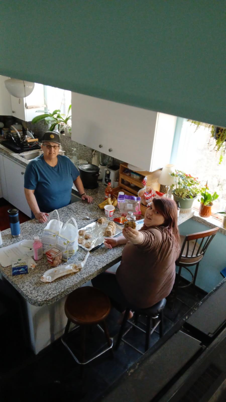 Two people preparing food at kitchen counter