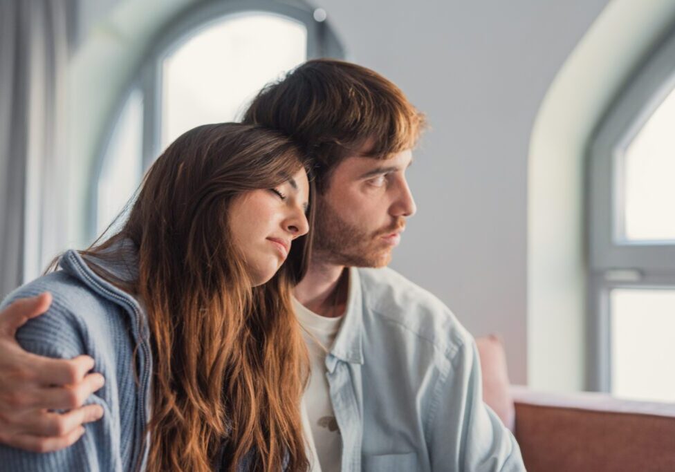 Two people sitting together in a calm setting, offering support during a difficult moment.