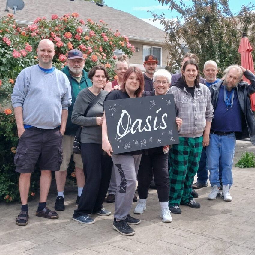 Group of people holding "Oasis" sign